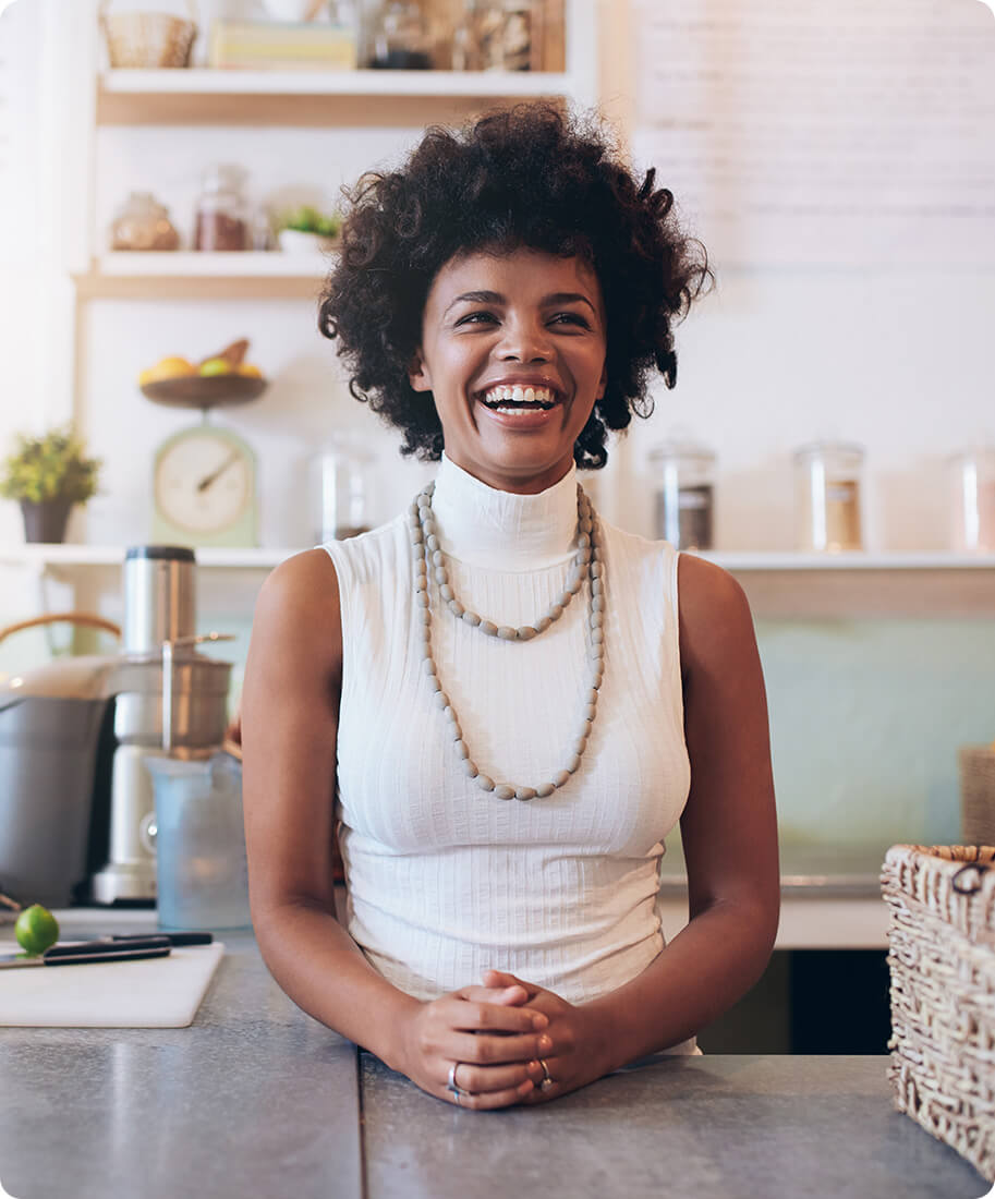 woman at a counter smiling with juicer in the background