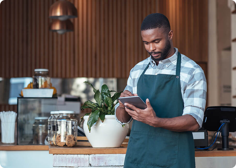 man looking at a tablet in a coffeeshop