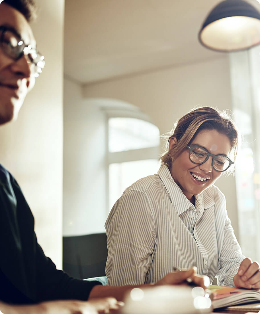 two people smiling sitting at a desk